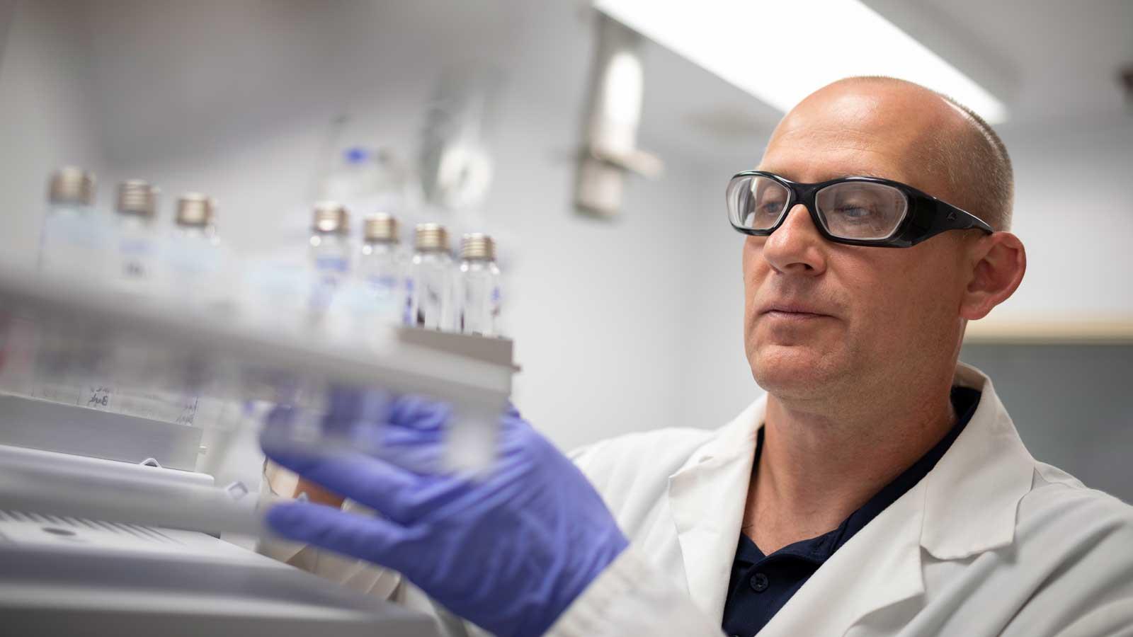 Man looking at vials