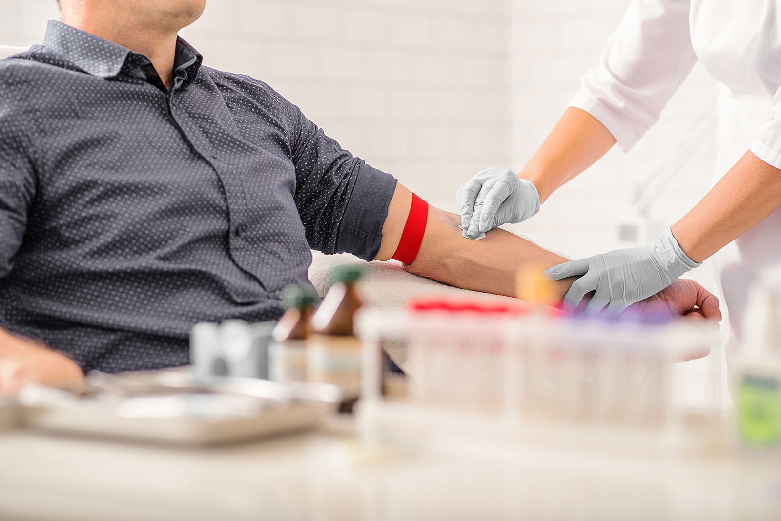 Nurse swabbing male patient arm for a blood test